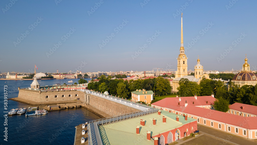 Aerial view of the wall of the Peter-Pavel's Fortress, Church next to the river and water channel in the historical city of St. Petersburg at sunny summer sunrise
