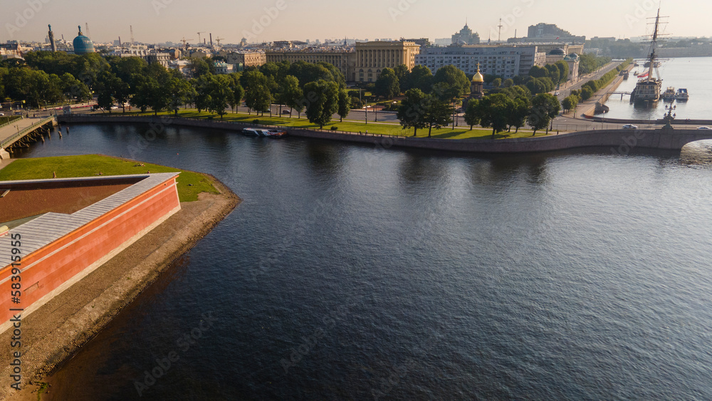 Aerial view of the Peter-Pavel's Fortress next to bridges and Sailing ship on the river and water channel in the historical centre of city of St. Petersburg at clear summer sunrise
