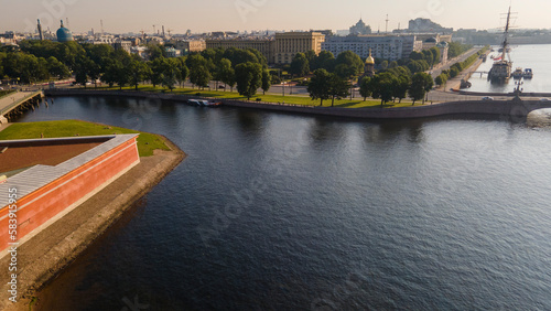Aerial view of the Peter-Pavel's Fortress next to bridges and Sailing ship on the river and water channel in the historical centre of city of St. Petersburg at clear summer sunrise