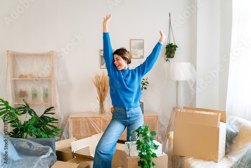 Happy woman with raised arms in new apartment