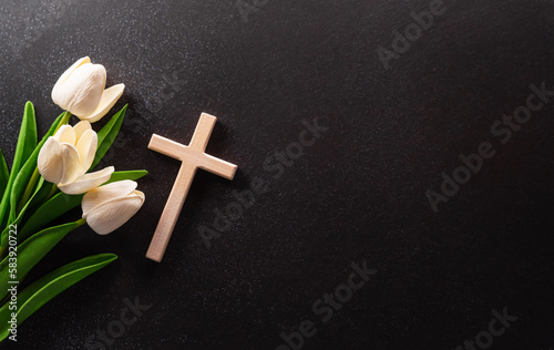 Good Friday and Holy week concept - A religious cross and flower on dark stone background.