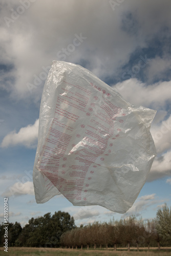 flying plastic bag in the wind above field in nature photo