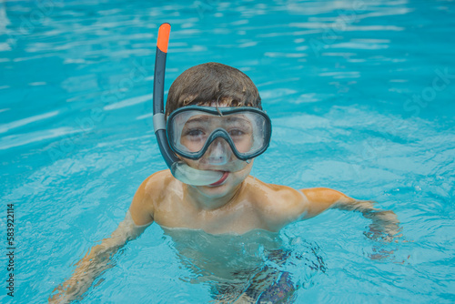 Menino na piscina com óculos de mergulho