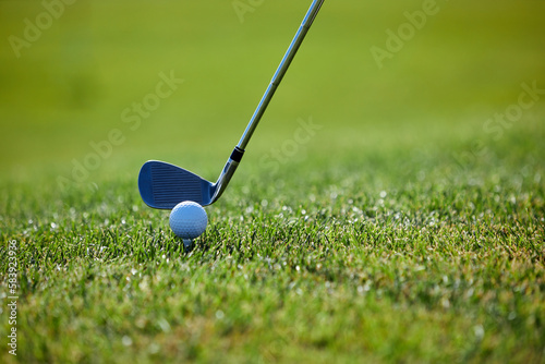 Close up of golf club hitting ball on green grass, copy space