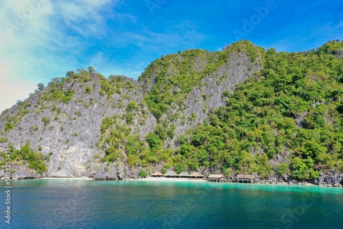 Panorama drone shot of majestic rocks in Coron, Palawan in the Philippines, covered with bushes and surrounded by the sea. © Monika