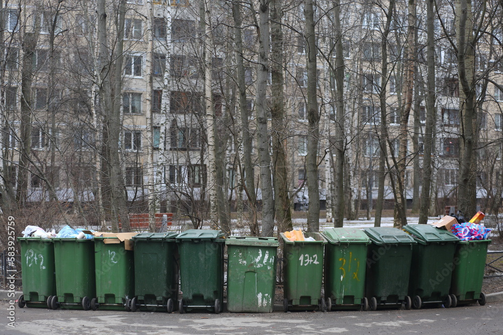Green plastic mobile containers with garbage in the courtyard of a residential building Green plastic mobile containers with garbage in the courtyard of a residential building