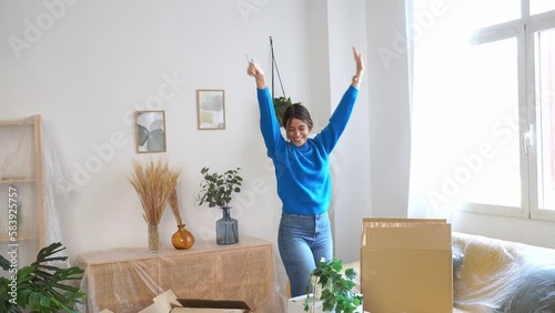 Happy woman with raised arms in new apartment photo