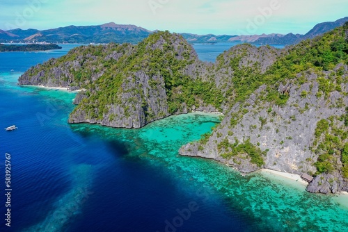 Fototapeta Naklejka Na Ścianę i Meble -  Panorama drone shot of majestic rocks in Coron, Palawan in the Philippines, covered with bushes and surrounded by the sea.