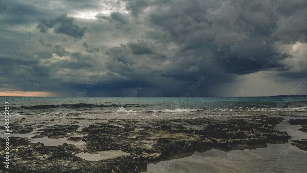 The sea churned and roiled beneath the brooding sky, as dark clouds loomed overhead and the distant rumble of thunder echoed across the horizon.