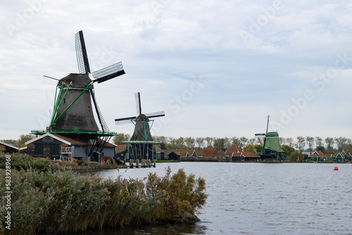 Traditional Old Green Windmills along the Zaan River in Zaanse Schans Netherlands