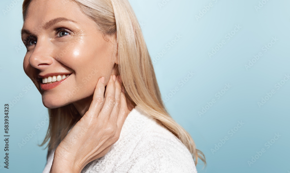 Beautiful 50s mid aged mature woman looking at camera isolated on blue. Mature old lady close up portrait. Healthy face skin care, middle age skincare cosmetics, cosmetology concept Beautiful 50s mid aged mature woman looking at camera isolated on blue. Mature old lady close up portrait. Healthy face skin care, middle age skincare cosmetics, cosmetology concept