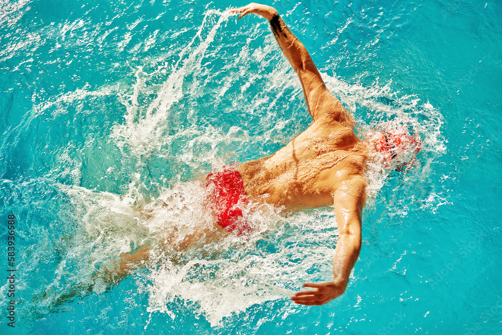 Male swimmer swimming in the pool, top view, butterfly style.