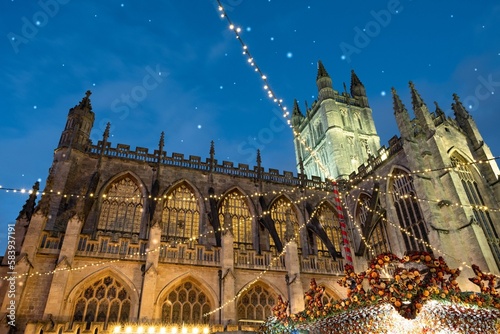 Low angle shot of Bath Christmas market stalls backdropped by the Abbey