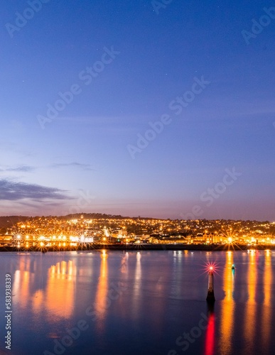 Nighttime view of the seaside port of Teignmouth from across the river Teign in Shaldon © Pez Photography/Wirestock Creators