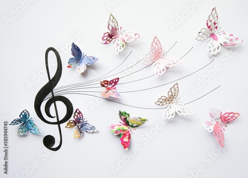 Closeup of colorful paper cut out butterflies eminating from an artistic musical staff photo