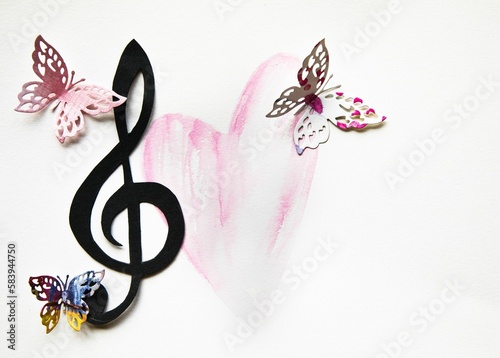 Colorful paper cut out butterflies with a musical treble cleff and a handrawn pink heart photo