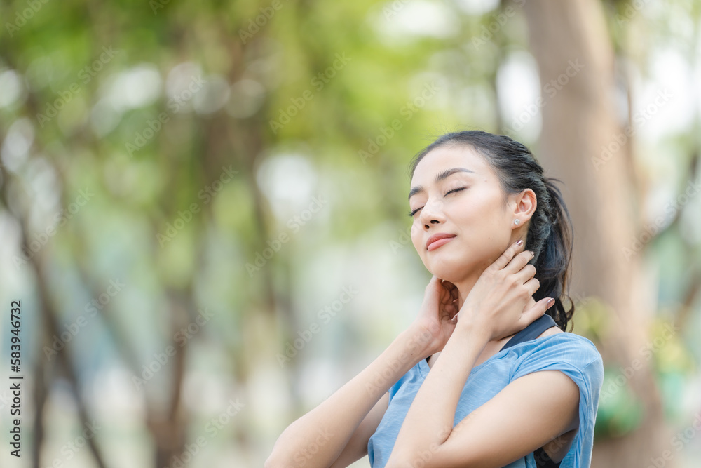 Asian woman stretching body and neck after jogging exercise at park in the city. Attractive athlete girl in sportswear enjoy outdoor lifestyle sport training fitness running workout in morning summer