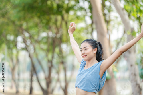 Asian woman stretching body and neck after jogging exercise at park in the city. Attractive athlete girl in sportswear enjoy outdoor lifestyle sport training fitness running workout in morning summer