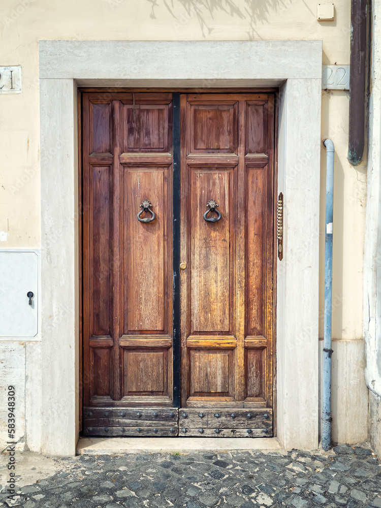 An old decorated vintage door with metal door handles in historical centre of Rome, Italy