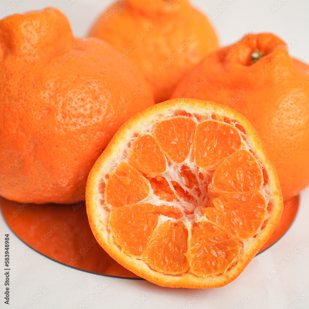 A set of oranges put together on a white table.