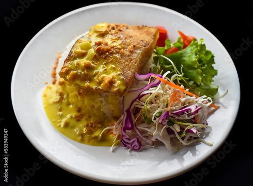 Grilled basa fish with rice and salad on black background