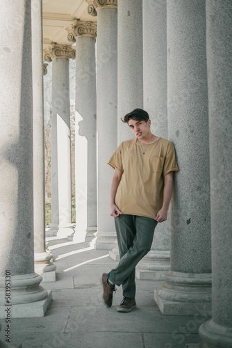 young man walking and posing with columns
