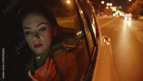 Young smiling Businesswoman in the car is reading messages on her mobile