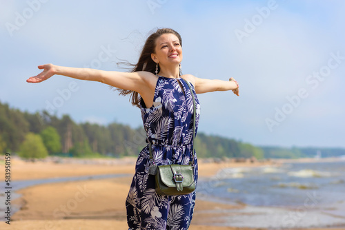 young beautiful woman, girl on beach breathing fresh air, turning her face to sun and wind. concept of freedom, vacation, travel © Елена Якимова