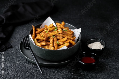 Closeup of tasty spicy Peri French Fries with sauces served on the side photo