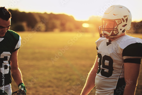 Football players talking during an afternoon practice photo