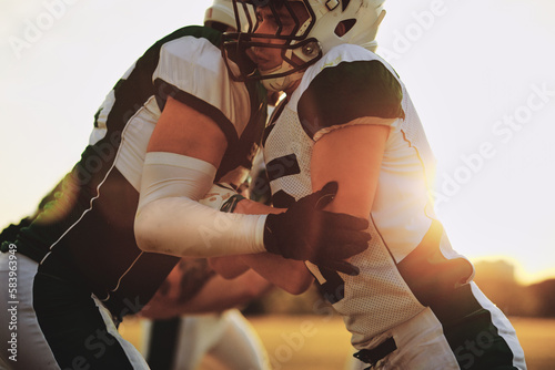American football players blocking each other during practice