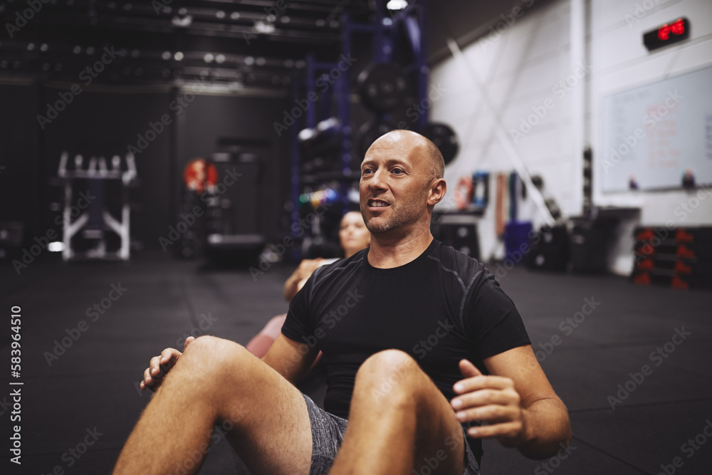 Mature man doing crunches during an exercise class Mature man doing crunches during an exercise class