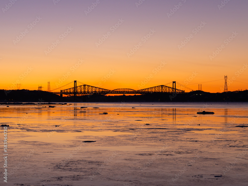 The 1970 Pierre-Laporte and the 1904 Quebec bridges over the St. Lawrence river in silhouette before sunrise, Cap-Rouge area, Quebec City, Quebec, Canada
