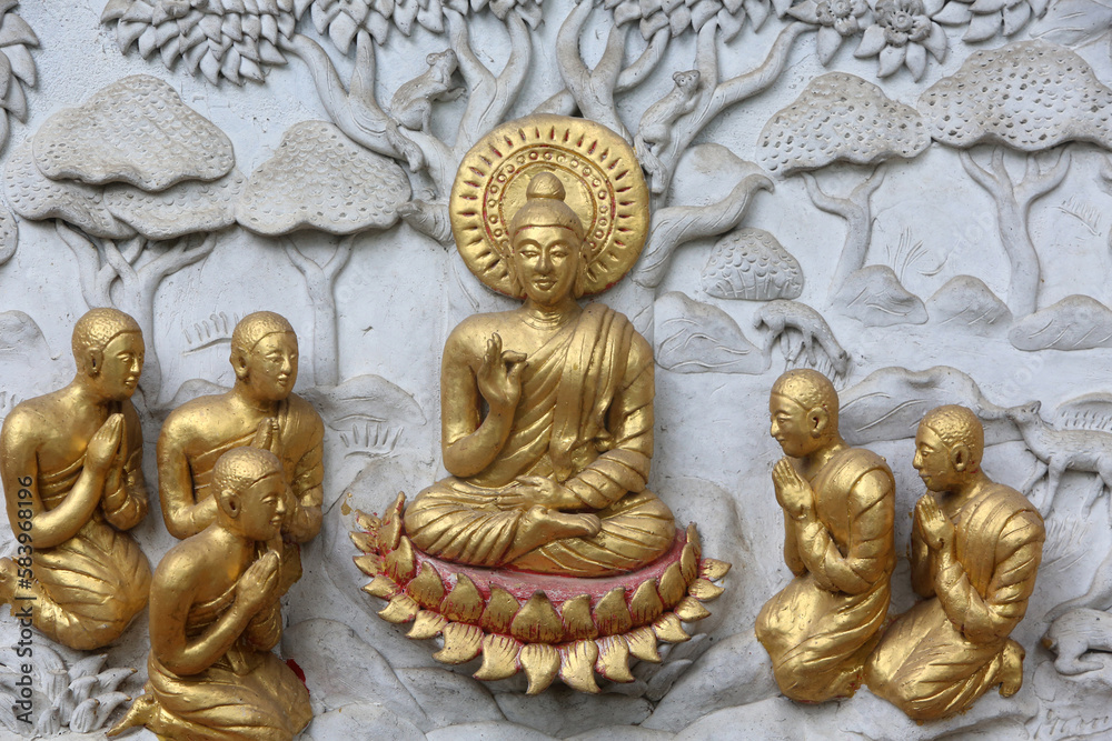 Relief depicting a scene of the Buddha's life in Wat Chai Mongkhon, Chiang Mai. Buddha surrounded by disciples. Thailand Relief depicting a scene of the Buddha's life in Wat Chai Mongkhon, Chiang Mai. Buddha surrounded by disciples. Thailand
