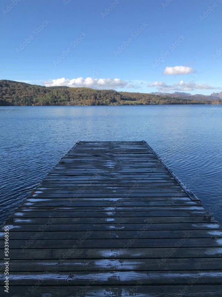 Obraz premium Lake view with a wooden jetty and a blue sky background. Lake Windermere England. 