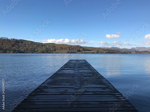 Lake view with a wooden jetty and a blue sky background. Lake Windermere England. 