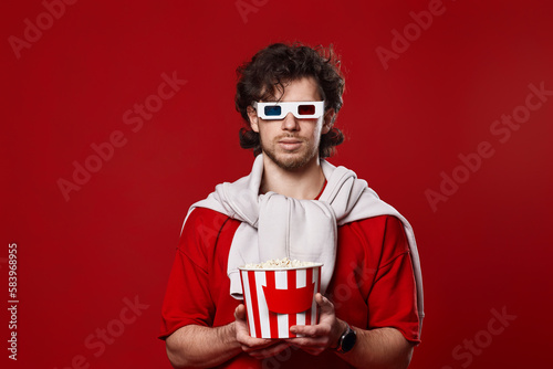 man in 3d glasses holding big bucket of popcorns