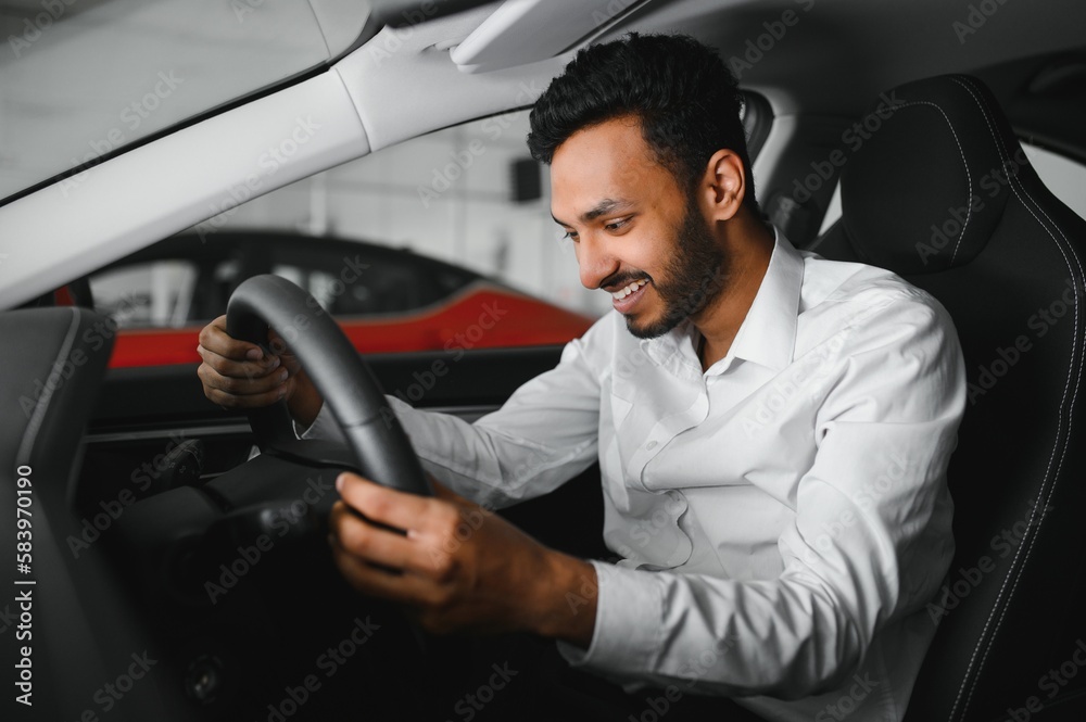 Young man sitting inside new car. Smiling Young man sitting inside new car. Smiling