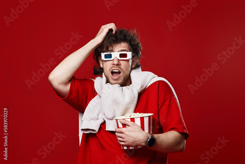 scared man in 3d-glasses holding bucket of popcorn © producer