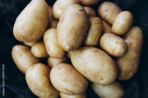 A pile of potatoes on a black background 