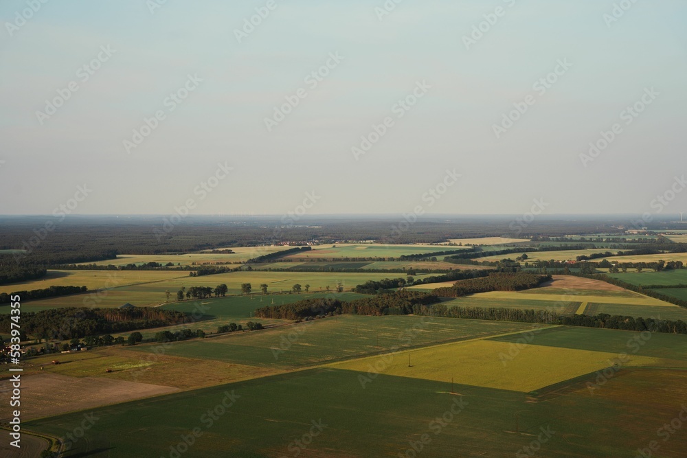 Aerial view over forests and fields on a foggy day