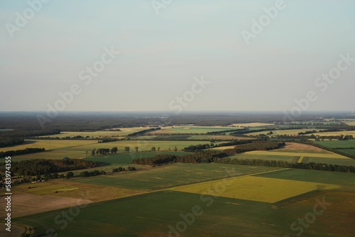 Aerial view over forests and fields on a foggy day