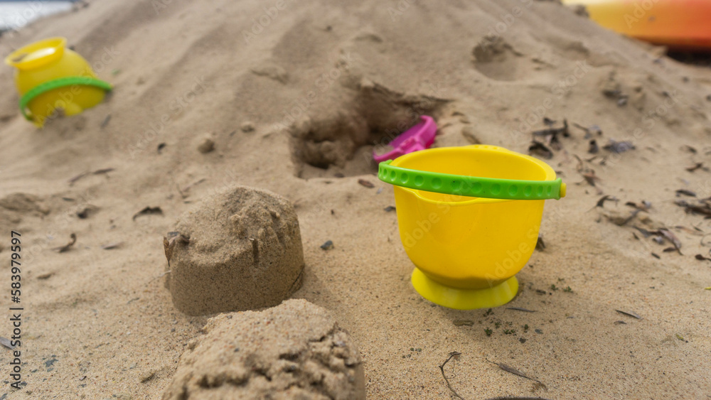 abandoned yellow bucket children's toy lying in the sand abandoned yellow bucket children's toy lying in the sand