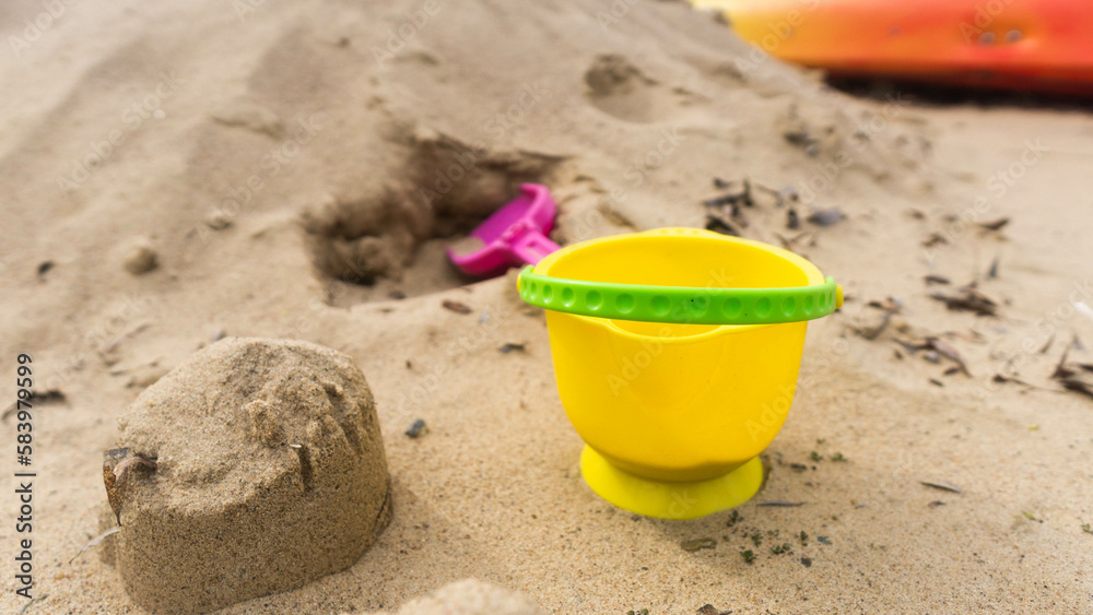 abandoned yellow bucket children's toy lying in the sand abandoned yellow bucket children's toy lying in the sand