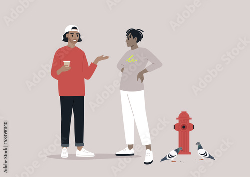 In an urban atmosphere, two young hipsters encountered each other on the street, engaging in conversation while one sipped on a to-go coffee near a fire hydrant and a flock of pigeons