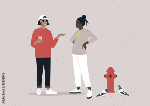 In an urban atmosphere, two young hipsters encountered each other on the street, engaging in conversation while one sipped on a to-go coffee near a fire hydrant and a flock of pigeons