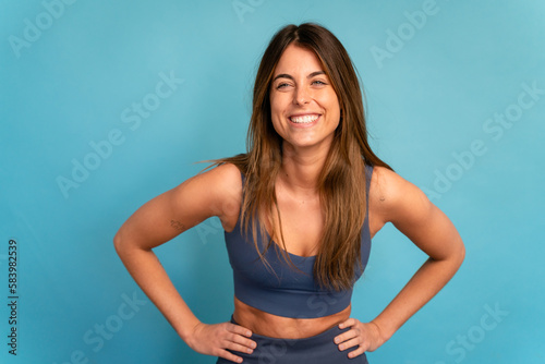 Принти на полотні Smiling sportswoman with hands on waist in studio