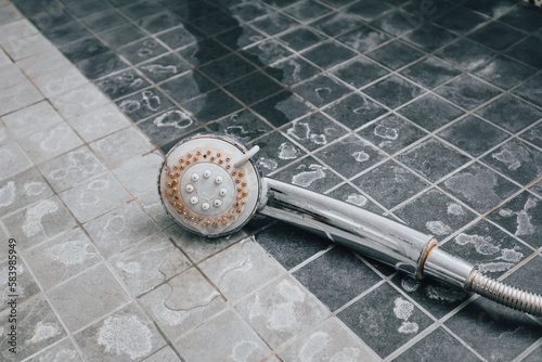 Silver shower head with limescales. Shower damaged from water scale. photo