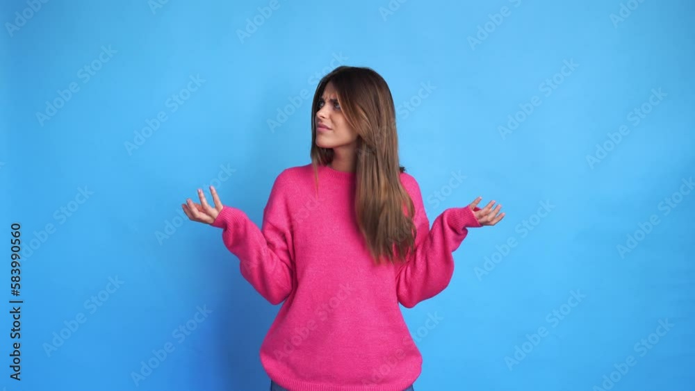 Young woman in sweater pointing at camera in studio Young woman in sweater pointing at camera in studio