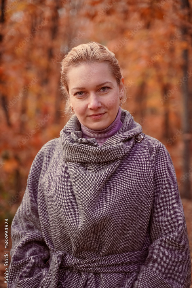Beautiful smiling woman walking outdoors in autumn forest. Brown toned.